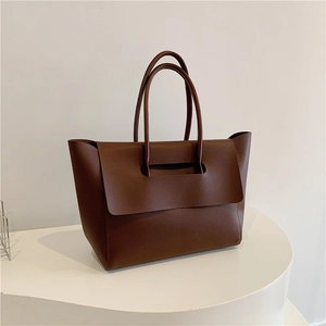 Minimalist brown matte leather tote bag featuring slim double handles and large front flap