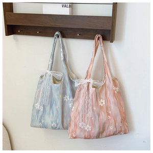 Detail of floral embroidery and lace bow on lightweight aesthetic tote bag