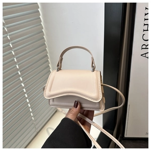 Dettaglio mini borsa beige in pelle PU con patta e tracolla sottile in luce naturale