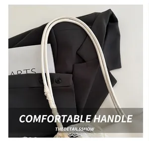 Détail de la poignée du sac en cuir blanc avec bordure en dentelle et coutures élégantes