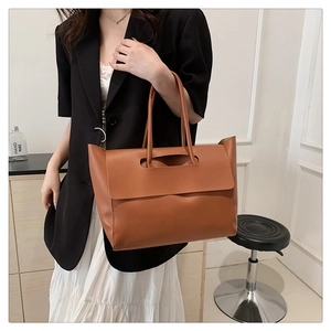 Detail of caramel brown leather tote bag showing handle design and spacious structure