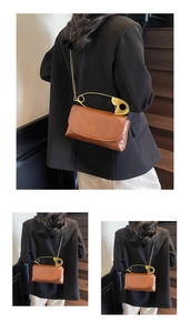 Sac bandoulière en cuir marron avec grande épingle de sûreté dorée et bandoulière chaîne