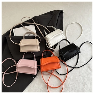 Detailed close-up of colorful mini top handle bags in white, pink, khaki, and orange