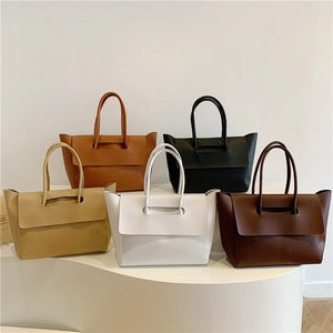 Minimalist leather tote bags shown in five versatile colors on a display stand