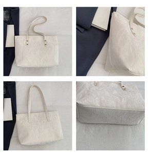 Dettaglio della borsa tote crema plissettata con manici rinforzati e trama in nylon