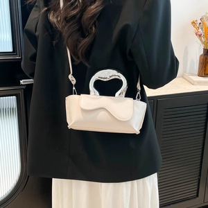 Creamy white designer handbag with wave flap and silver horseshoe handle in modern style