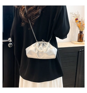 Detail view of silver pleated crossbody bag with pearl handle and slim chain strap
