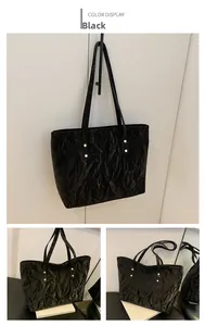 Dettaglio della borsa tote nera con trama in pelle e rivetti dorati vintage