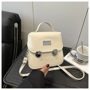Gros plan du sac vintage crème avec boucles argentées et texture en cuir synthétique