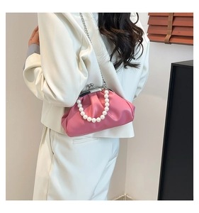Pink pleated cloud bag detail featuring pearl handle and silver chain strap for dinner