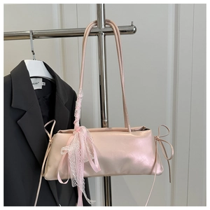Détail du sac sous l'aisselle rose nacré avec dentelle, nœuds et plis soyeux
