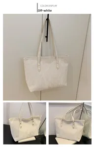Dettaglio della borsa tote color crema con trama marmorea e rivetti dorati