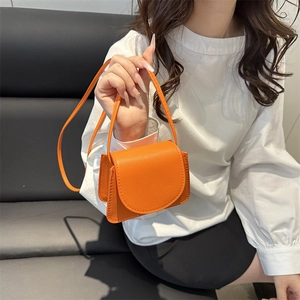Chic orange faux leather crossbody bag with a minimalist design and thin shoulder strap
