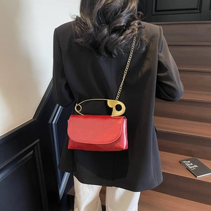 Red square shoulder bag with a unique gold paperclip handle and fine chain strap for women