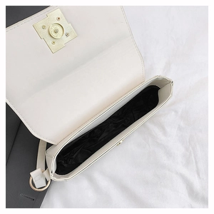 Detailed interior view of white crossbody bag with gold hardware and spacious single compartment