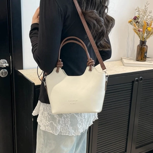 Chic beige bucket bag with brown circular handles and detachable strap for women