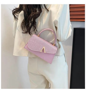 Detail of pink sequin shoulder bag with golden V-clasp and metallic chain strap