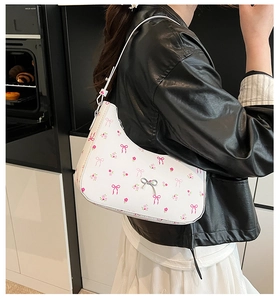 Detail of white floral shoulder bag with pink bows and silver metallic butterfly buckle
