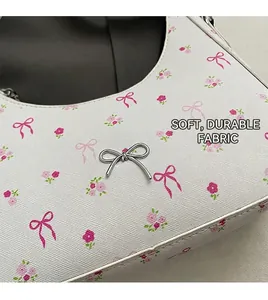 Detail of floral print handbag showing Saffiano texture and silver bow charm