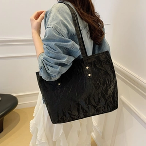 Borsa tote nera minimalista con trama plissettata e dettagli in fibbia metallica