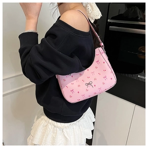 Detailed view of pink floral hobo bag with bow prints and metal buckle charm