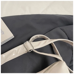 Detail of cream leather shoulder strap with silver adjustable buckle and fine stitching
