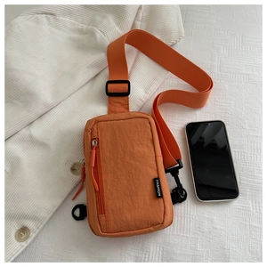 Compact orange waterproof nylon crossbody bag with fashion label and adjustable strap