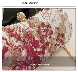 Detail shot of pink floral embroidery and gold rhinestone sphere clasp on evening clutch bag