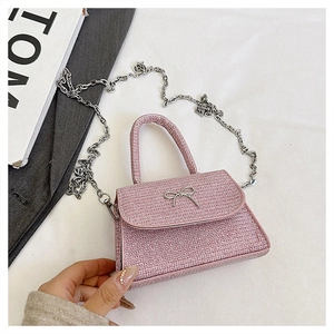 Detailed close-up of pink glitter woven bag featuring silver butterfly metal buckle