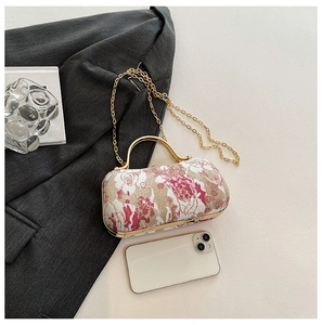Detailed close-up of floral jacquard embroidery bag with vintage gold metal handle