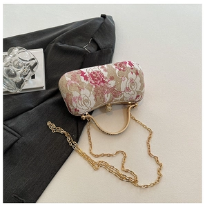 Detail of elegant rectangular clutch bag with floral embroidery and gold metal handle
