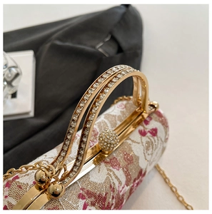 Macro shot showing crystal-encrusted gold handles and floral embroidery on evening bag