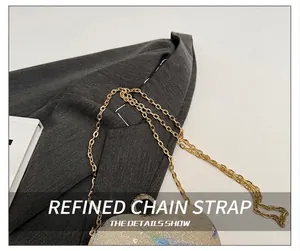 Close-up of elegant gold chain strap on a shimmering heart sequin handbag detail