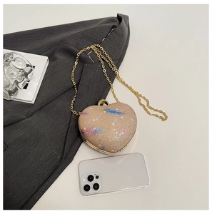 Detail of champagne heart-shaped sequin clutch bag with feather prints and metal chain