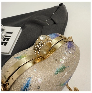 Detailed close-up of champagne sequin handbag with rhinestone ring clasp and metal chain