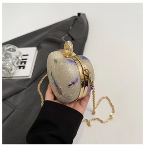 Close-up of heart-shaped evening clutch with champagne sequins and crystal ring clasp