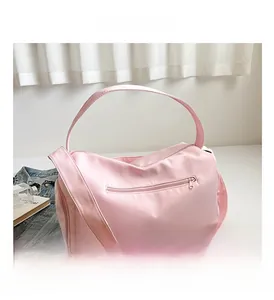 Detailed view of pink waterproof nylon gym bag with front zipper and wide shoulder strap