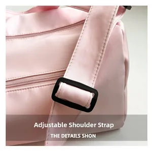 Close-up of pink fitness bag showing adjustable nylon shoulder strap and buckle