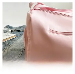 Detail shot of the pink waterproof nylon fabric and zipper pocket of this travel duffel