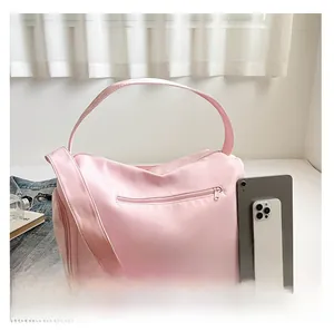 Detail showing the pink nylon fitness bag size compared with a tablet and phone