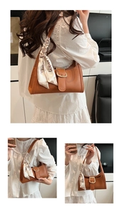 Détail du sac porté épaule marron à motif crocodile avec foulard et boucle dorée