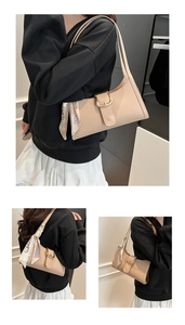 Détail du sac baguette beige motif crocodile avec boucle dorée et foulard en soie décoratif