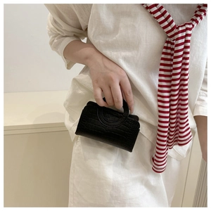 Close-up of black crocodile-embossed PU leather tote bag with circular handle