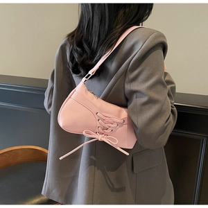 Detailed back view of pink balletcore underarm bag with decorative ribbon laces and bow