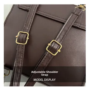 Detail of dark brown leather backpack with adjustable shoulder straps and gold buckles