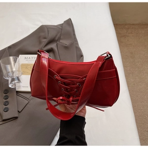 Détail du sac sous le bras en cuir verni rouge avec laçage de style corset chic