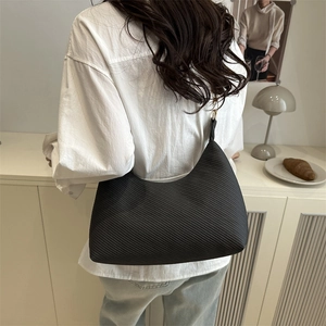 Minimalist black hobo shoulder bag with textured finish shown on a female model