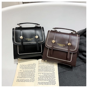 Detail view of vintage satchel bags with gold bead trim in black and mocha brown colors