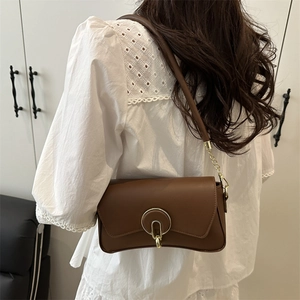 Chic brown leather shoulder bag with a gold metal U-clasp and chain strap detail