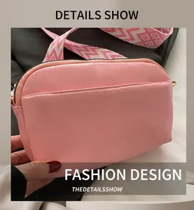 Detail of pink small square bag featuring geometric wave pattern woven shoulder strap